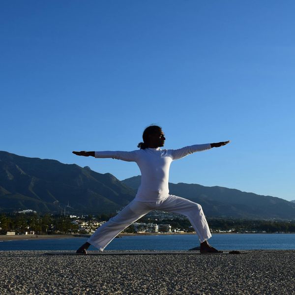 Silhouette of a man stretching against a sunrise.